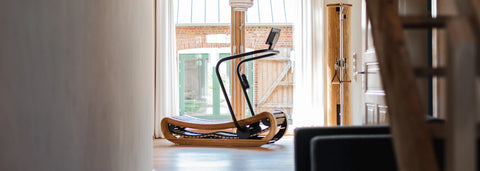 An oak NOHRD SprintBok in a modern home, in-front of a large window overlooking a courtyard.